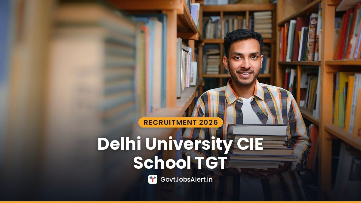 Student holding books in a library aisle - Delhi University CIE School TGT and Assistant Teacher Recruitment 2026